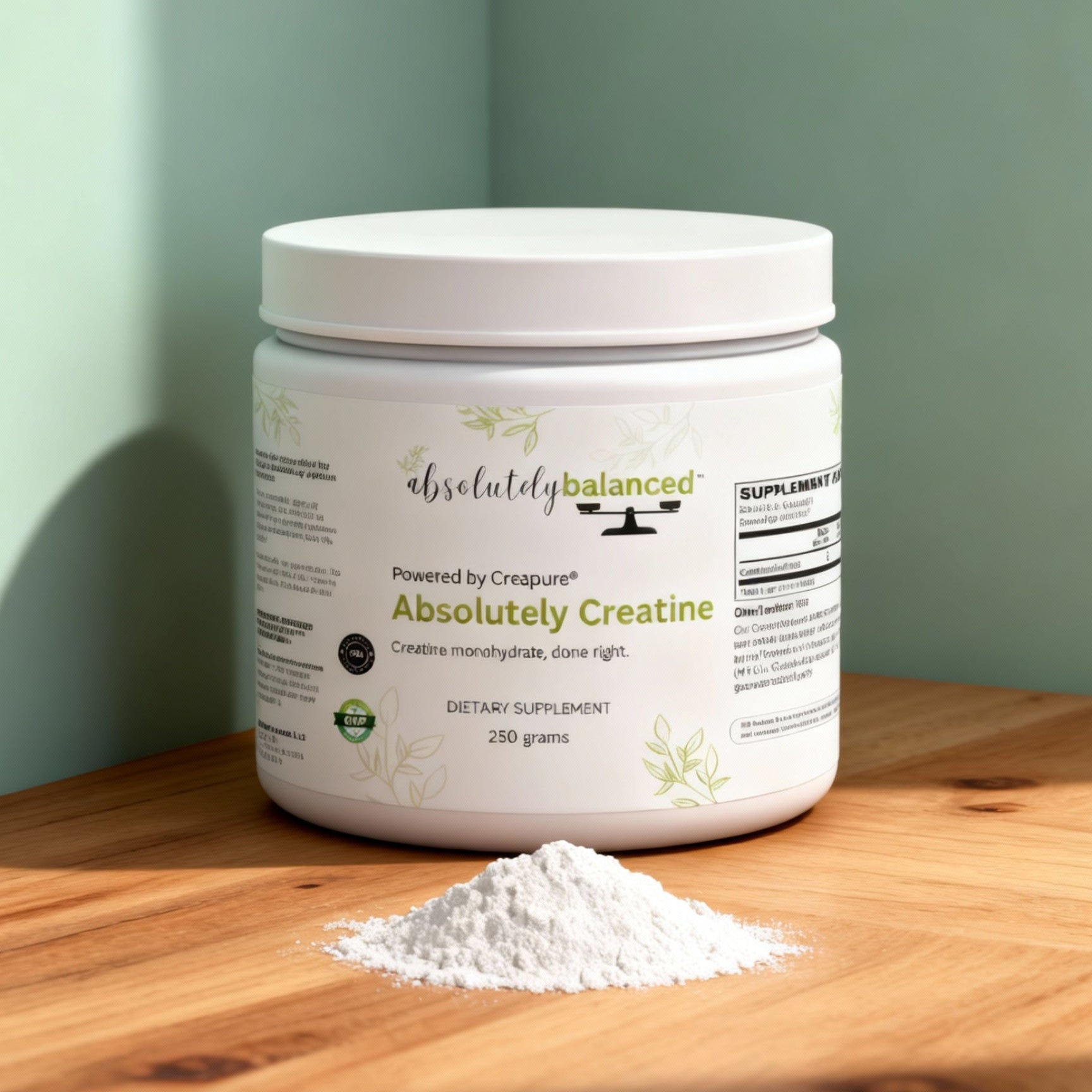 Container of Absolutely Balanced Absolutely Creatine on a wooden surface with a light green background